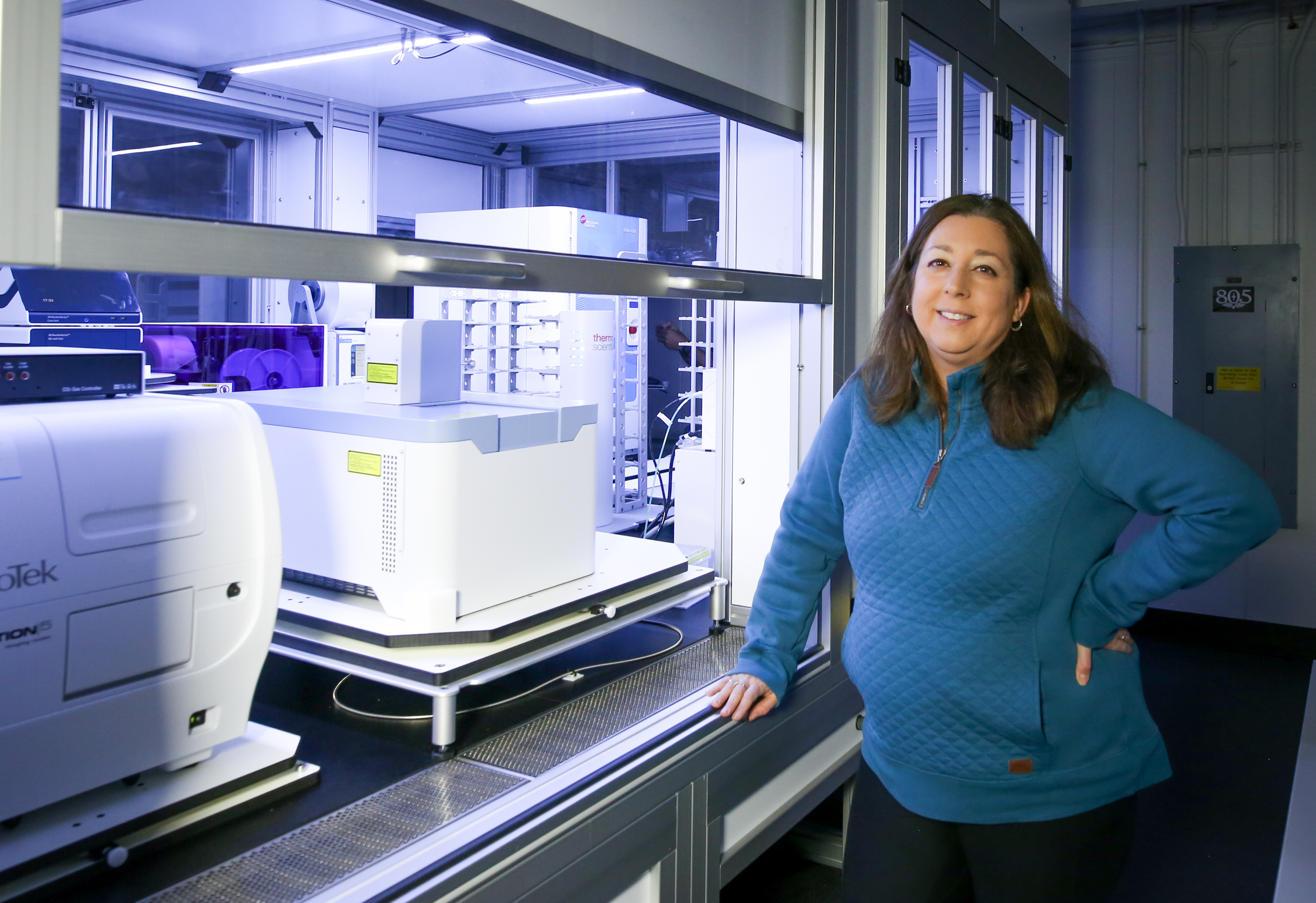 Michelle O’Malley standing besides lab equipment