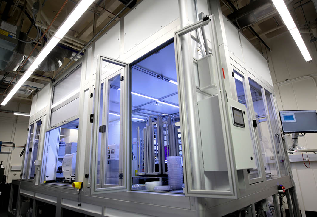 Glass structured room with violet lighting and instruments inside