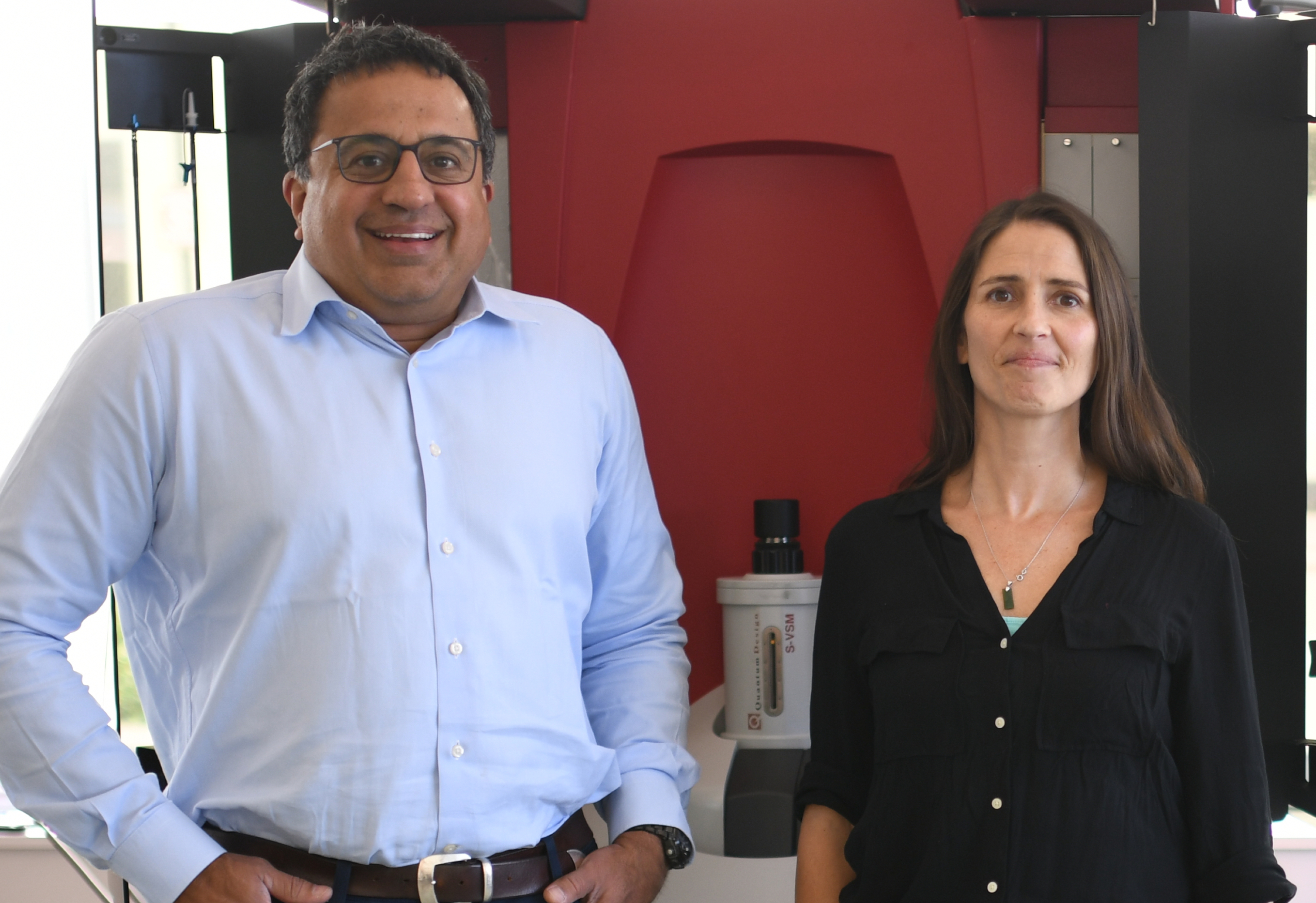 Ram Seshadri and Amanda Strom standing in front of large instrument