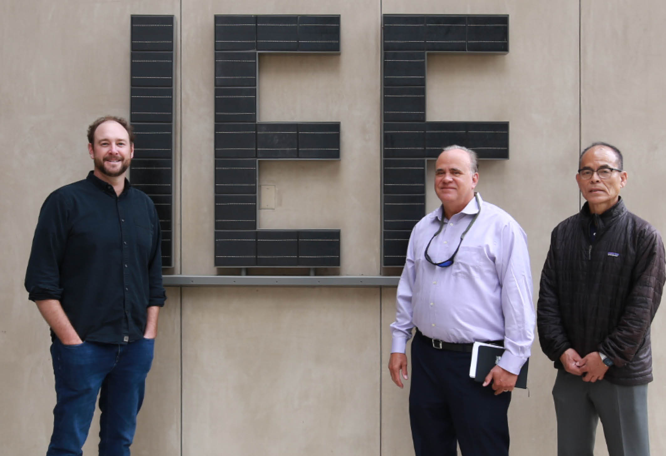 Phillip Christopher, Steven DenBaars, and Shuji Nakamura standing in front of building with large IEE lettering.