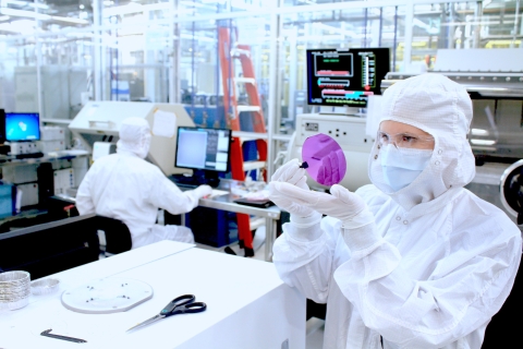 A researcher examines a wafer fabricated inside the UC Santa Barbara Nanofabrication Facility. 