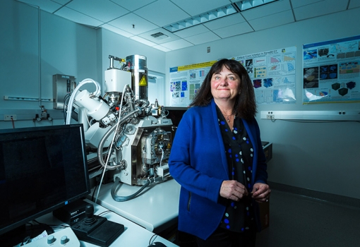 Tresa Pollock beside a combined laser and electron-beam tomography system