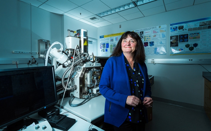 Tresa Pollock beside a combined laser and electron-beam tomography system